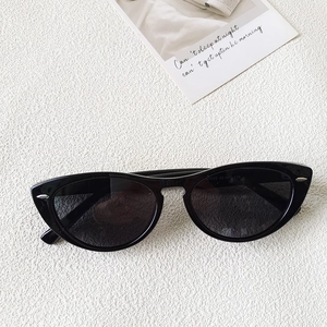 Macro detail of cat eye sunglasses model R9020 with polarized lenses on white leather