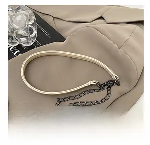 Détail de la bandoulière en cuir épais avec chaîne en métal gris foncé sur un sac