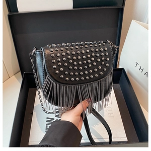 Détail du sac bandoulière noir avec clous argentés et franges en chaînes métalliques