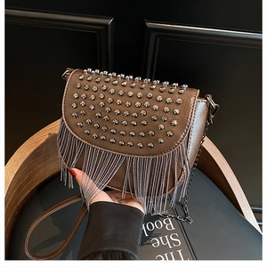 Détail du sac selle marron avec rivets métalliques et franges de chaînes argentées