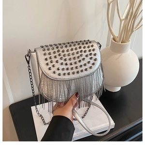 Détails du sac bandoulière argenté avec clous gris foncé et franges en chaîne