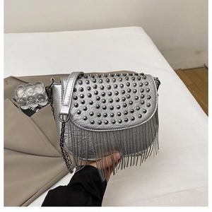 Détail du sac bandoulière argenté avec clous métalliques et franges de chaînettes pendantes