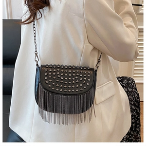 Détail du sac besace noir avec des rivets argentés et de longues franges en chaîne