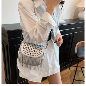 Vue détaillée du sac bandoulière argenté avec clous et franges porté par un mannequin