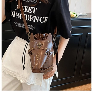 Detailed view of dark brown pig-shaped crossbody bag with bronze rivets and drawstring closure