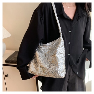 Detail of silver sequin bucket bag with white braided rope shoulder strap on a model