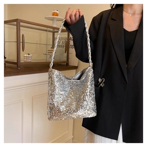 Close-up of a silver sequined bucket bag with metallic woven strap in a retro interior