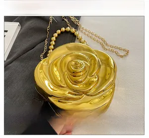 Detailed macro of golden rose-shaped evening bag with petal texture and pearl handle