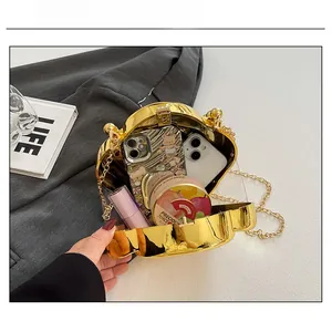 Detailed internal view showing capacity of a gold metallic evening clutch bag with chain