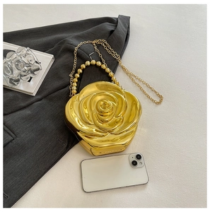 Detail of golden rose acrylic clutch featuring petal textures and metallic chain