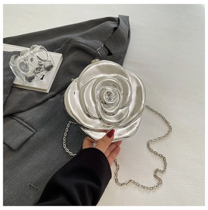 Detail of silver metallic rose evening clutch bag with high-gloss plating and chain
