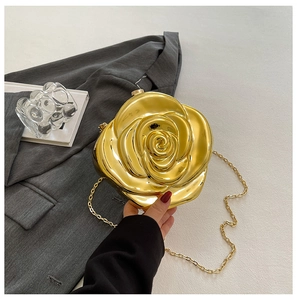 Detail of gold rose-shaped clutch bag with intricate 3D petal texture and chain strap