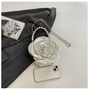 Detailed view of silver rose-shaped acrylic evening bag with beaded handle and chain strap