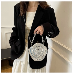 Detailed view of a 3D silver rose petal clutch with metallic finish and beaded handle