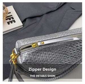 Close-up of metallic silver woven bag featuring gold-tone zipper and leather puller