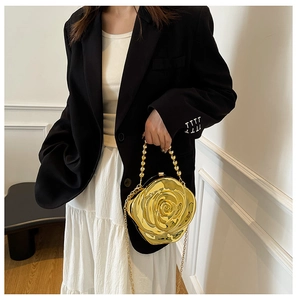 Detailed view of golden 3D rose-shaped acrylic clutch bag with metallic chains