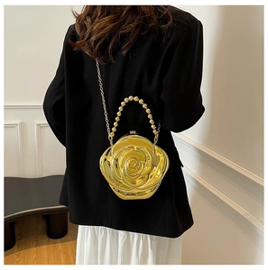 Detailed view of golden 3D rose evening bag with metallic petals and beaded handle