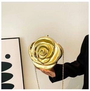 Detailed view of hand-held gold rose-shaped evening clutch bag with chain strap