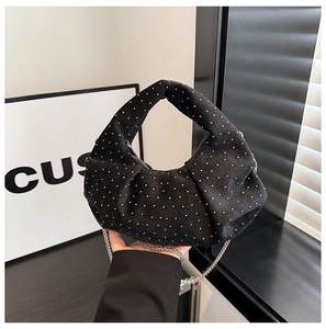Detail of black crescent handbag with sparkling rhinestones and woven handle strap