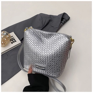 Detail of silver woven bucket bag with metallic texture and FASHION & BAGS metal plaque