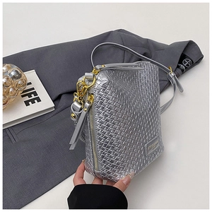 Close-up of silver woven bucket bag featuring premium metallic texture and gold hardware