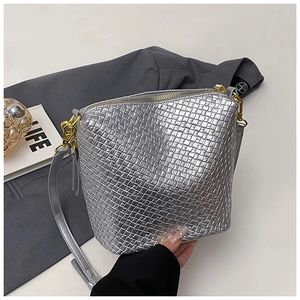 Close-up of metallic silver woven dumpling bag featuring gold metal zipper and hardware