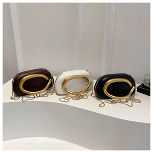 Detalle de bolsos de mano ovalados con logo en C dorado y correas de cadena de metal