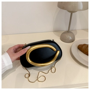 Elegante bolso de mano tipo caja negro con una llamativa hebilla metálica dorada en C.
