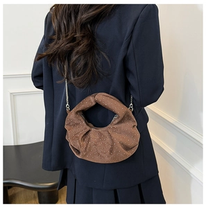 Brown moon bag with pleated suede fabric and white dots shown on a model back view