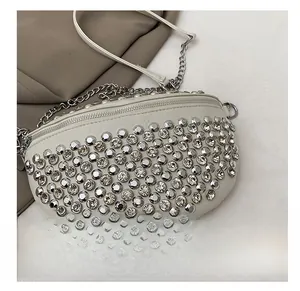 Gros plan du sac banane blanc orné de rivets argentés et de détails en strass brillants