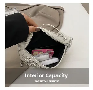 Détail de l'intérieur spacieux d'un sac blanc à strass montrant la doublure noire chic