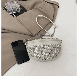 Détail du sac banane blanc en demi-cercle avec rivets argentés et bandoulière chaîne