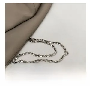 Close-up of premium metal chain and pearl bead details on a sequined handbag