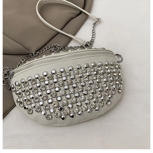 Détail du sac croissant blanc avec rivets argentés, strass et bandoulière chaîne
