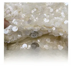 Detailed macro view of white sequins and silver magnetic snap closure on handbag