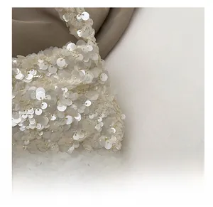 Close-up of high-density pearlescent sequins and silver chain detail on white cloud bag
