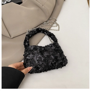 Close-up of black sequin handbag with elegant silver chain strap for evening party use
