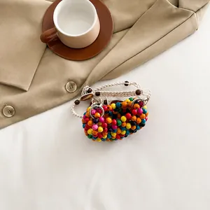 Dettagli delle perline colorate e del manico intrecciato di questa borsa boho