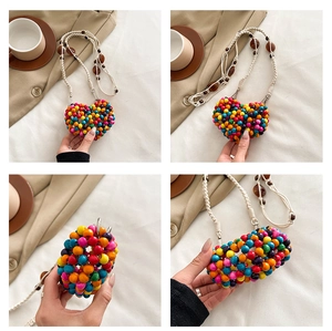 Detail of multi-colored heart-shaped beaded bag with handcrafted woven shoulder strap