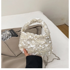 Detail of white sequin handbag with smooth metallic chain and elegant gathered pleats