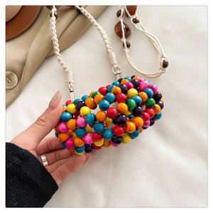 Detailed macro view of vibrant multi-color beaded mini bag with white woven rope strap