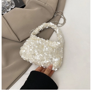Close-up of white sequin texture and silver chain strap on a stylish evening handbag