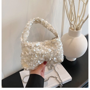 Detailed close-up of white sequin texture on cloud bag with silver chain strap and top handle