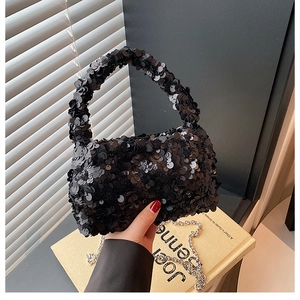 Detail of black sequined handbag with shimmering texture and detachable silver chain strap