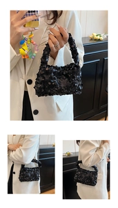 Detail of black sequin crossbody bag featuring sparkling texture and delicate metal chain strap