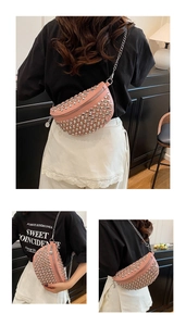 Sac banane rose en forme de lune avec rivets et bandoulière chaîne sur modèle