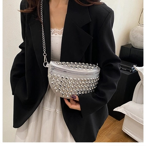 Détail d'un sac bandoulière argenté orné de clous avec une bandoulière en chaîne métallique