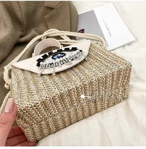 Détail de la base du sac en paille tressée beige avec texture artisanale