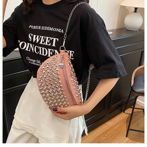Détail d'un sac banane punk rose avec des rivets métalliques argentés et une chaîne