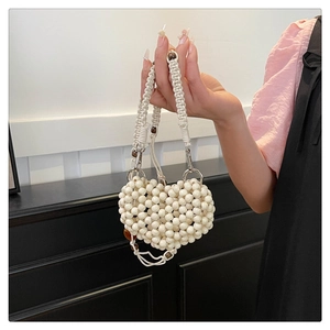 Detailed close-up of handmade cream heart-shaped beaded mini bag with silver metal ring